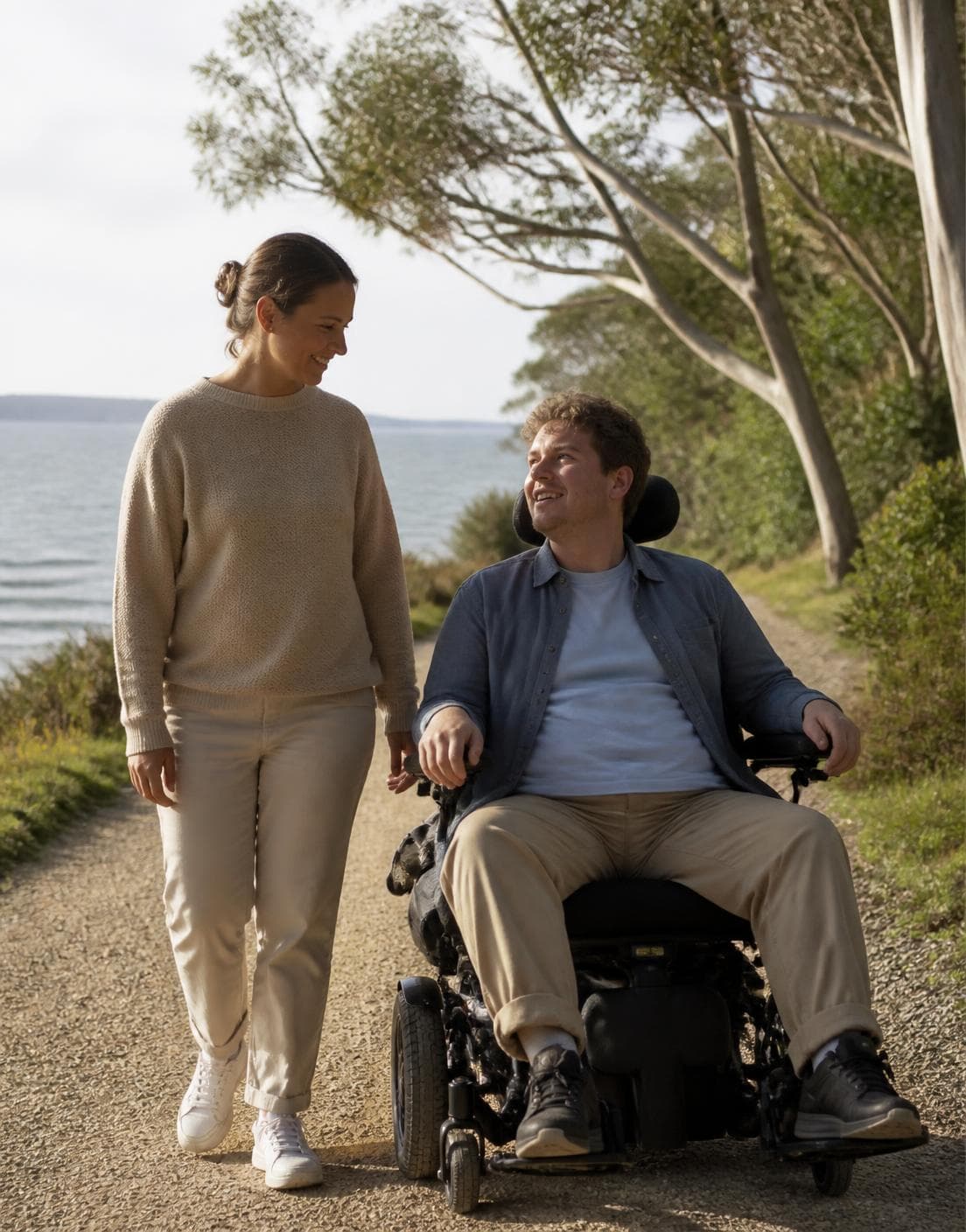 A support worker and a person she supports walking together outdoors